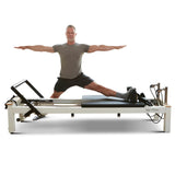 Person performing Pilates exercises on a reformer