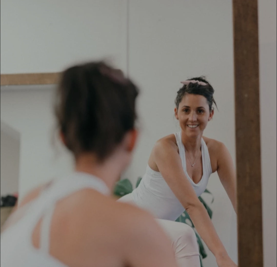 Mirror selfie with Pilates reformer in background